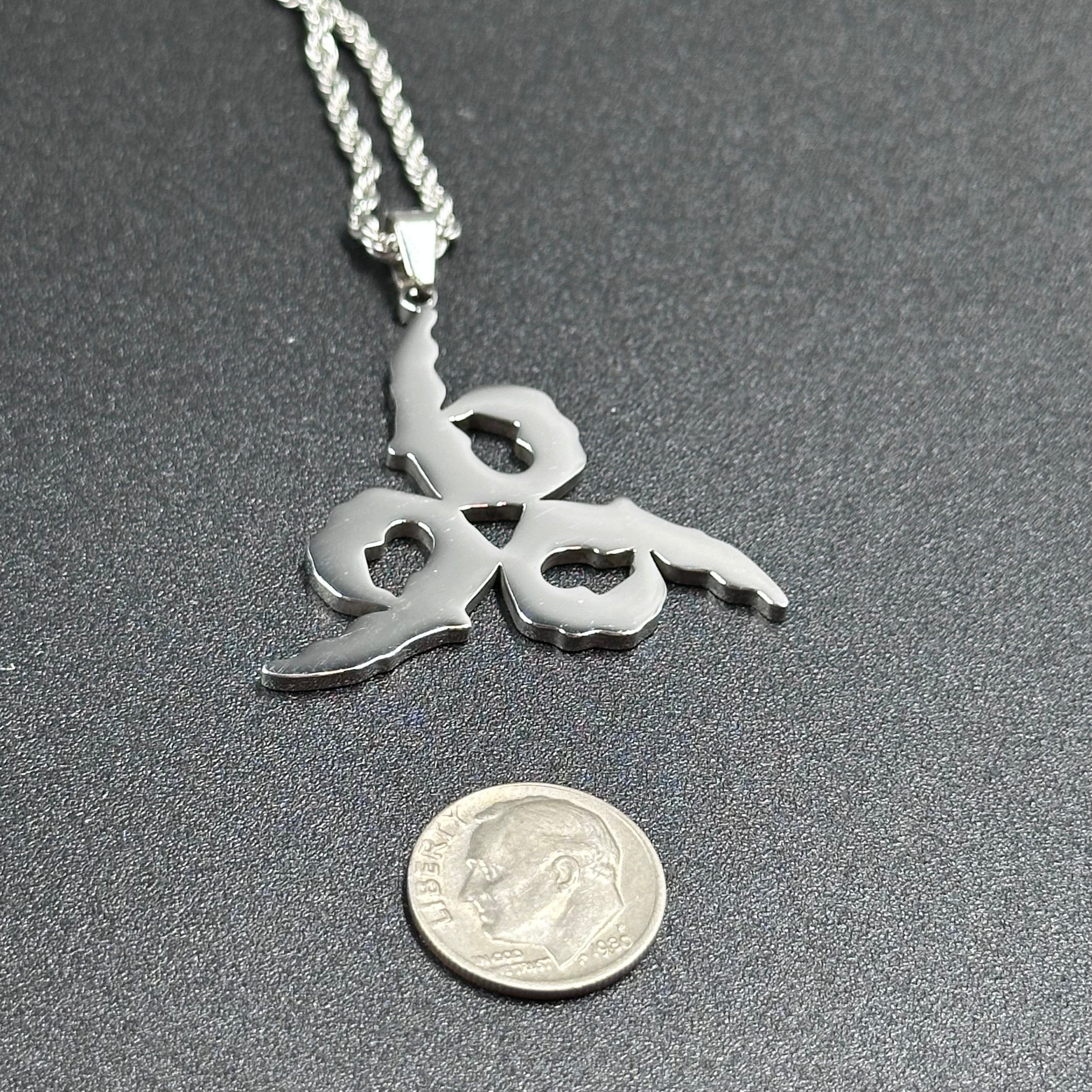 Juice WRLD 999 pendant beside a US dime for scale