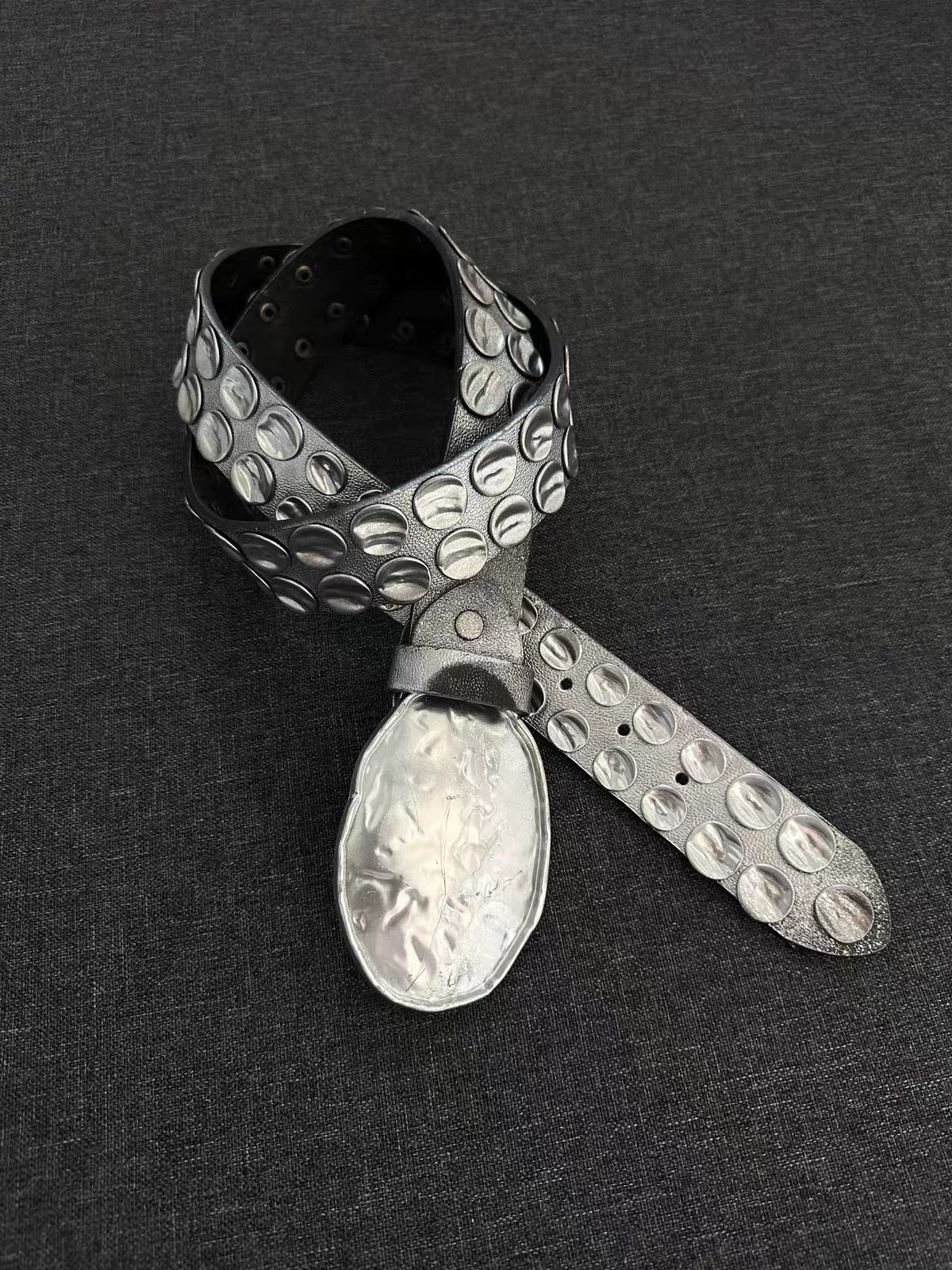 Hammered Silver Oval Buckle Studded Leather Belt on black background